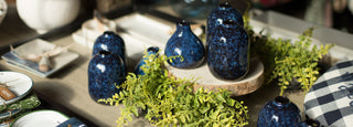 dark blue vases and greenery on display with summer items
