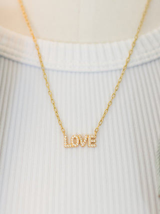 gold necklace with the word love emblazoned with rhinestones