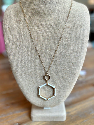 a gold statement necklace with an ivory bamboo hexagon pendant 