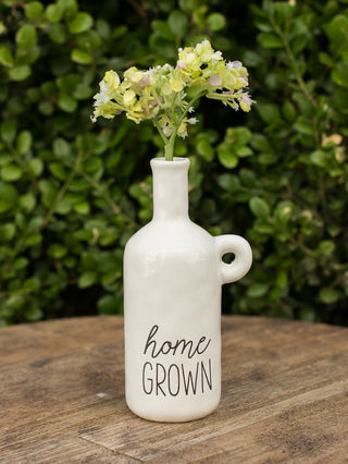a mottled ceramic white bud vase with creamy glaze and debossed sentiment that reads home grown