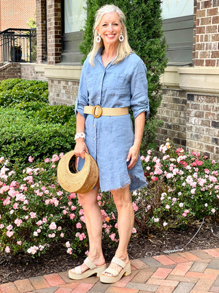 breezy linen chambray blue button down dress with collared neckline and fringe shirt cut hem worn with natural heels