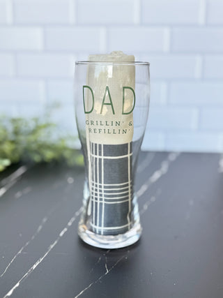 Clear beer glass with dad message and grey and cream grilling towel