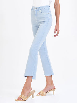 fitted high rise cropped flare jeans in a sky blue color worn with natural heels