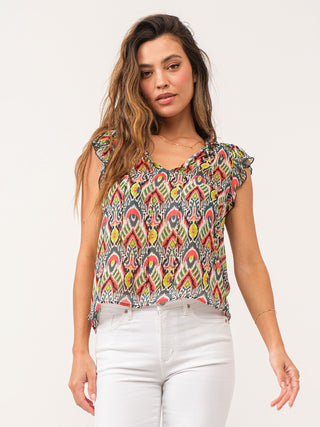 a relaxed fit colorful tribal print top with ruffle cap sleeves