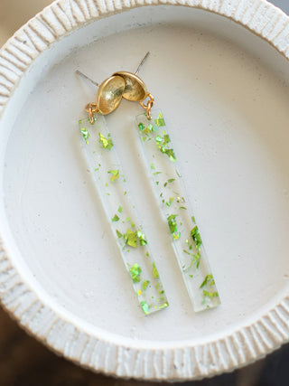 dangly clear acrylic bar earrings with festive green speckles and gold posts