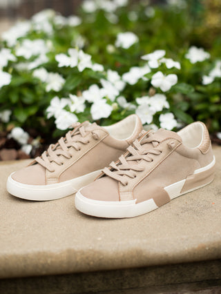 a pair of beige sneakers with vintage details in a low top style perfect for everyday wear