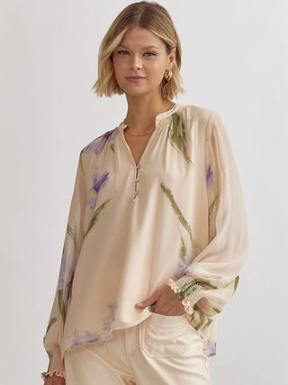 a long sleeve beige silk blouse with lavender and green floral patterns