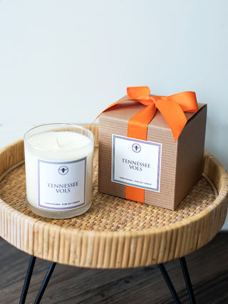 a hand poured amber musk and sage candle and gift box with tennessee vols printed on both