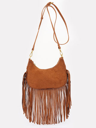 a boho style camel tan suede crossbody with a crescent shape and fringe trim