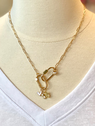 a gold link chain necklace with a butterfly and heart clip charm