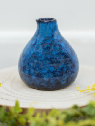 a deep blue vase with black marbling