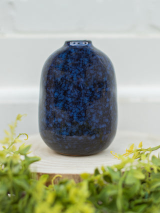 a dark blue vase with black streaks