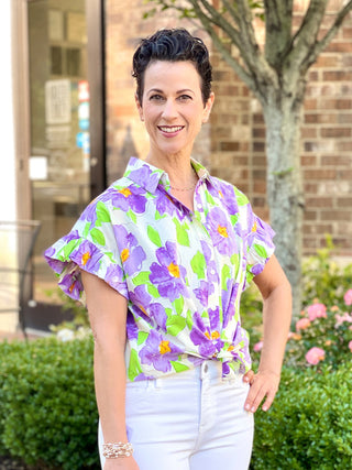 a purple and green floral collared blouse with button down front and ruffled short sleeves