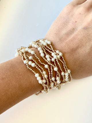 a bright stack of gold and pearl bracelets to wear with your favorite outfit