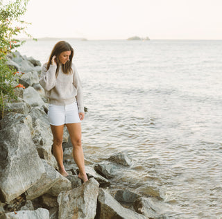 woman walking on rocks at edge of beach