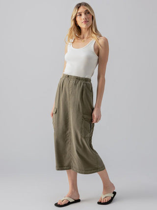 stylish olive green cargo skirt with cargo pockets and an elastic waistband worn with a white tank top