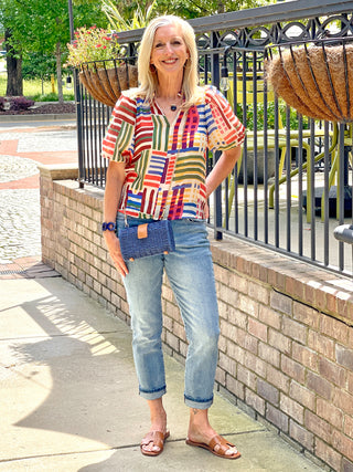 colorful vintage patchwork striped top with elastic puff sleeves and ruffled collar worn with blue jeans