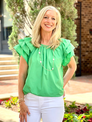 vibrant green pleated top with layered ruffled short sleeves