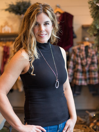 wear this black halter mock turtleneck as an alluring winter layer or dress it up for holiday parties