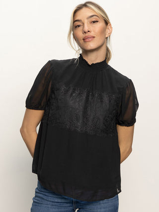 black blouse with sheer short sleeves and lace details with ruffle mock neck