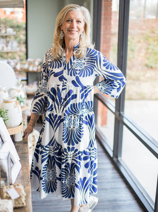 a blue and white patterned midi dress with a tiered skirt and long sleeves