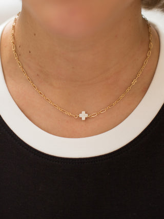 a faith based gold necklace with a small ivory cross