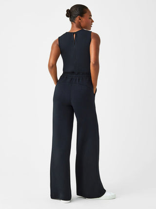 ultra soft and comfortable black spanx jumpsuit with wide legs and pinch draw string waist worn with white shoes