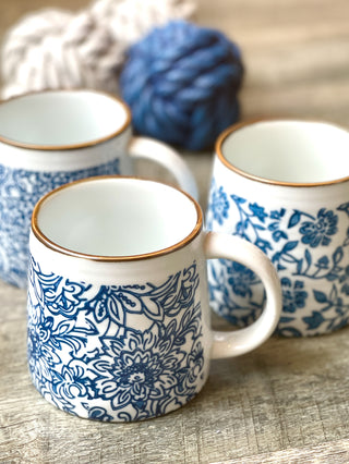 hand stamped stoneware mugs in unique blue floral designs and a gold rim