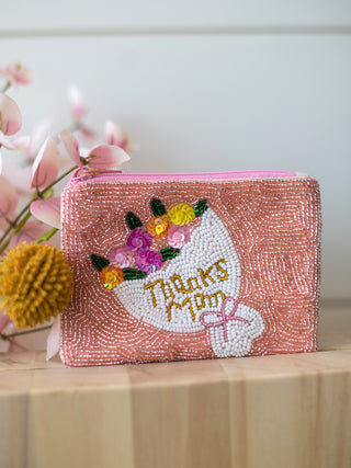 a pink beaded coin bag with a zip closure and sequin flowers and thanks mom embroidered as a mothers day gift