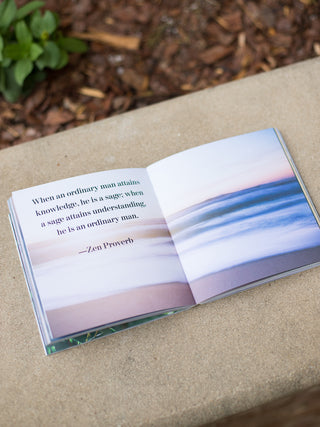 a spiritual quote inside the book set against a photo of the ocean shore