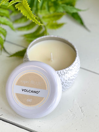 volcano scented candle in small white tin container with lid adjacent