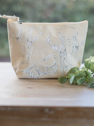 an adorable elephant print cosmetic bag in beige with a zipper closure