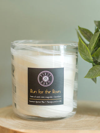 mint julep scented candle with notes of whiskey magnolia and tangerine in hand poured white glass vessel