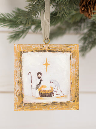 a gold wooden box ornament with a nativity scene painting
