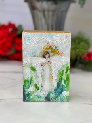 a hand painted block with a green and blue angel picture