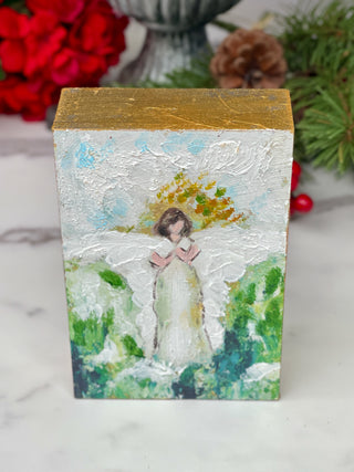 a hand painted block with a green and blue angel picture