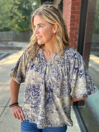 a chinoiserie print blouse in blue with ruffle details and puff sleeves in a feminine and lightweight cut