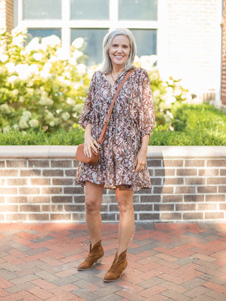 a brown floral mini dress with long flowing sleeves perfect for boho fall fashion shown with brown ankle boots