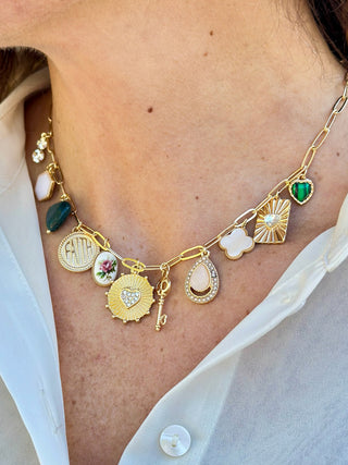 a fun gold chain necklace with large charms in different shapes and colors