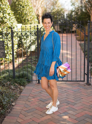 flattering chic crinkled blue mini dress with ruffle split neck worn with white sneakers