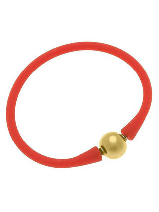an orange silicone stackable bali bracelet with gold plated bead clasp