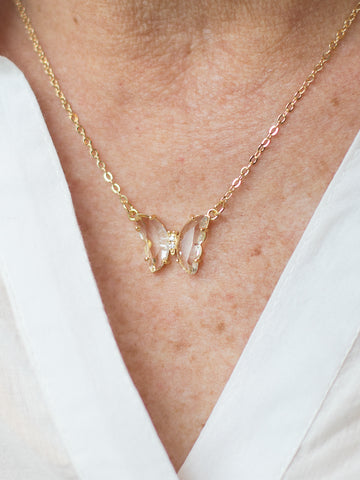a crystal butterfly necklace with rhinestone body and set on a gold cable chain with lobster claw closure