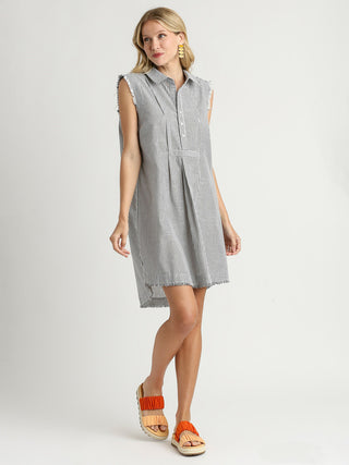 sophisticated black striped collared sleeveless dress with added fray worn with orange colored sandals