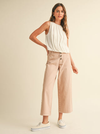 white linen blouse with billowy silhouette paired with tan pants