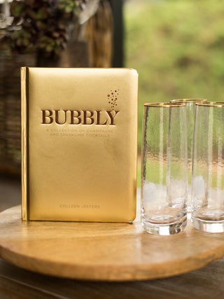 a champagne cocktail recipe book with a chic gold cover