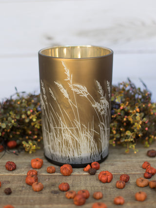 a gold bronze candle votive with waving grass in white along the sides perfect for fall home decor