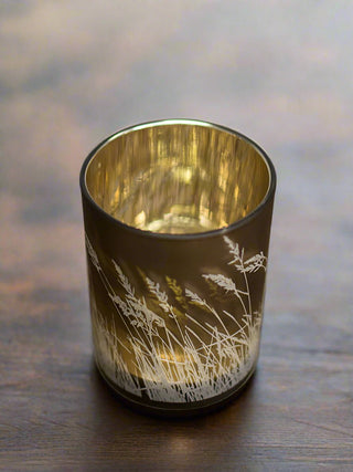 a gold bronze candle votive with white reeds printed along the side perfect for fall home decor