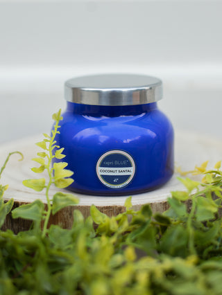 a coconut scented candle in a small blue glass jar