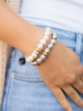a pearl stretch bracelet in silver with a string of exquisite pearls and a gold washer charm shown in a stack