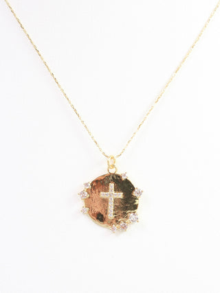 thin gold chain necklace holds a circular pendant with sparkly cz accents and cz cross